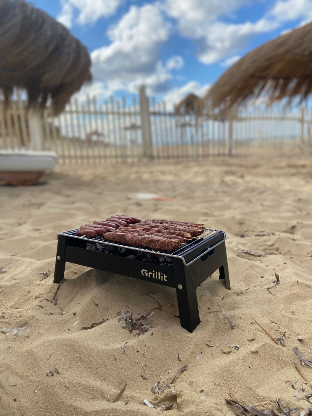 Grillit Slim portable charcoal grill cooking meat evenly on non stick grate